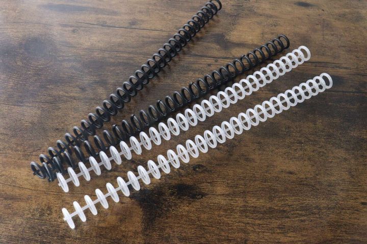 木目調のテーブルに黒と透明のカラー30リングが4本並べられている