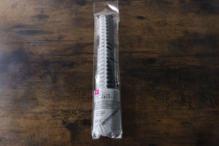 パッケージに入った透明と黒のカラー30リングが木目調のテーブルに置かれている