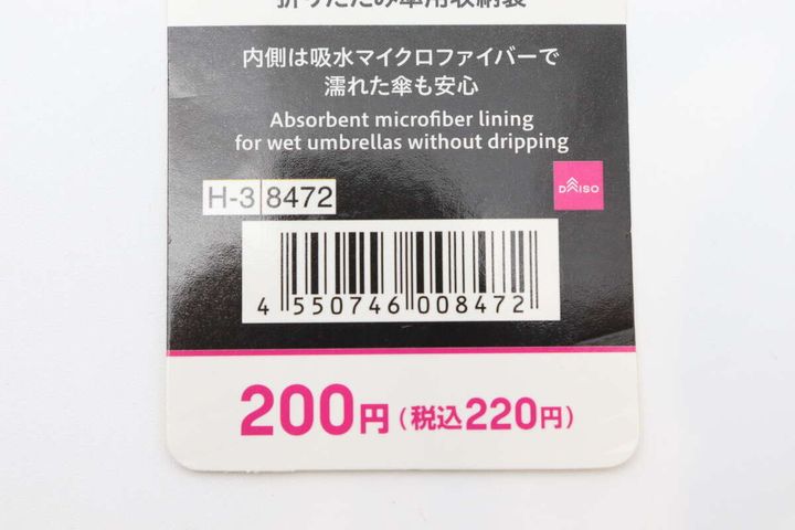 折りたたみ傘用収納袋のタグのアップ。商品名、価格、JANコード、吸水マイクロファイバーの記載が見える。