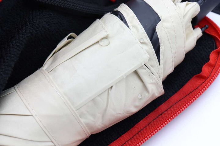 折りたたみ傘の表面に水滴が付いている様子。傘は収納袋の中に入れられている。