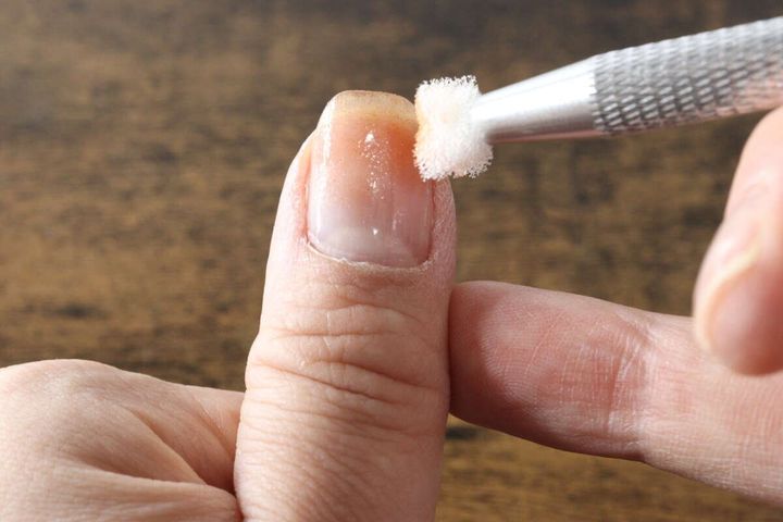 ペン型ツールで爪にネイル用スポンジをポンポンと押し当てている