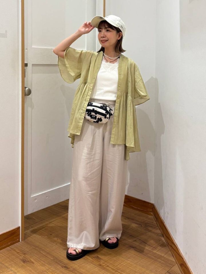 黄緑ペプラムブラウスと白Tシャツの女性