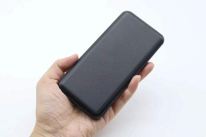 女性の手のひらに乗せられた黒いモバイルバッテリー