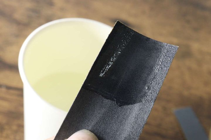 水に濡らして水研ぎの準備をしているサンドペーパーの表面のアップ