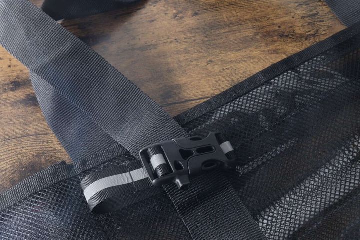 黒いバッグのストラップ部分に装着された反射材バックル