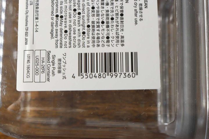 透明な密閉容器の底面に貼られたJANコードと商品情報の一部をクローズアップ