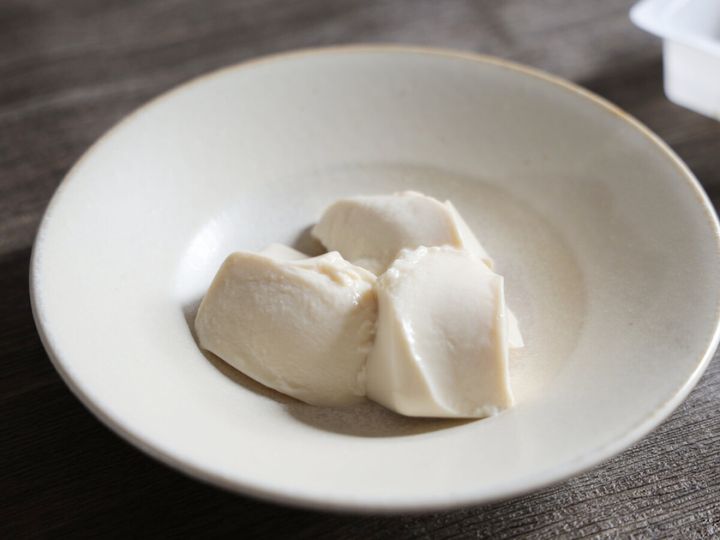 白い器にスプーンで大きくすくって盛り付けられた、やわらかい絹豆腐