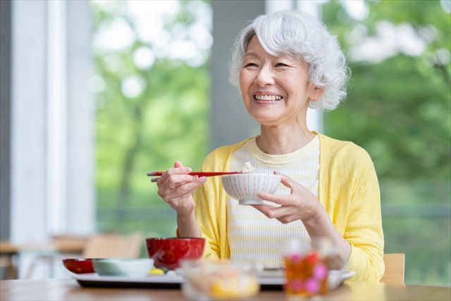 笑顔でご飯を食べる女性