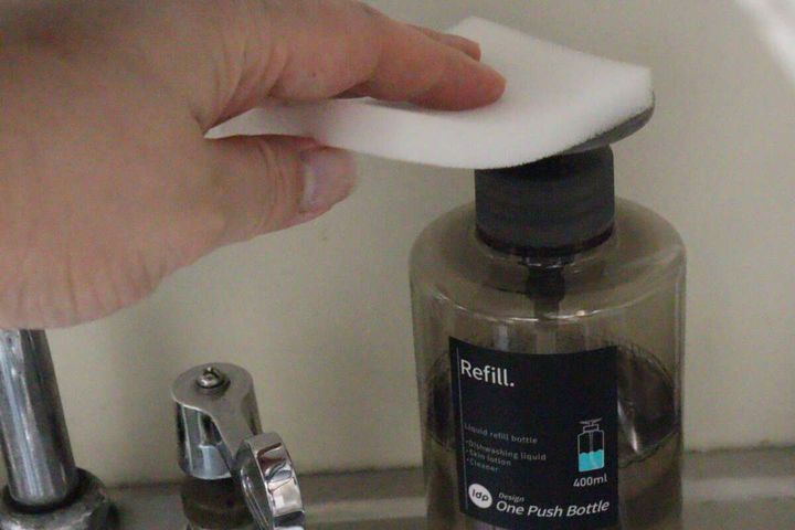 スポンジを使いワンプッシュボトルから洗剤を出している様子