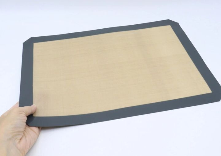 手で持ったグレーとベージュの電子レンジ用シリコーンマット