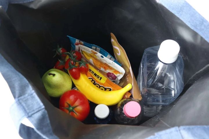 デニム調のトートバッグ（ポーチ付）の内部に食品や飲み物がたくさん入っている様子