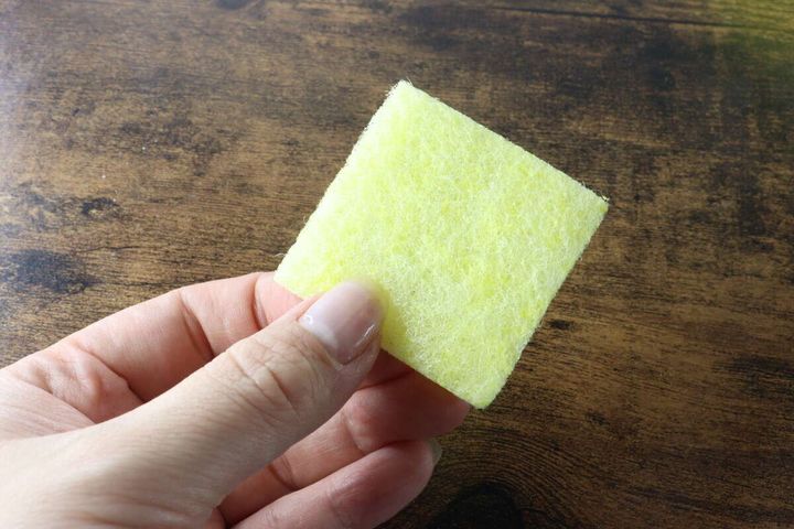 女性の手のひらに乗せられた黄色いクエン酸クリーナー1枚