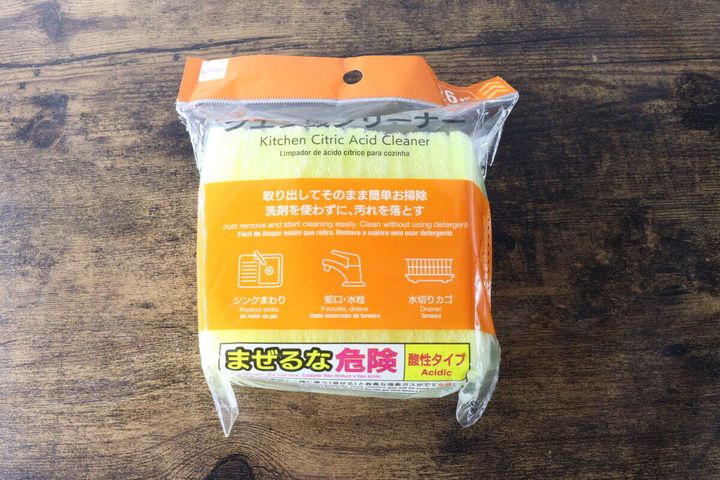 木目のテーブルに置かれたダイソーの黄色いクエン酸クリーナーのパッケージ