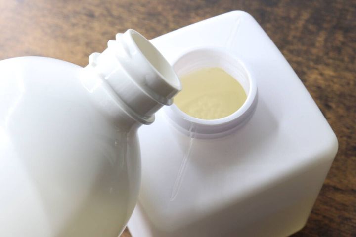ワンプッシュディスペンサーボトルに洗剤を注ぎ入れている
