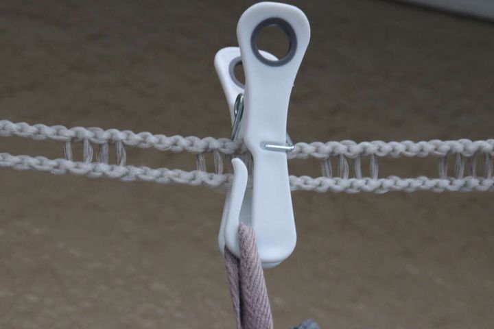 洗濯ロープに挟んだピンチのフックにループ付きの洗濯物を掛けている