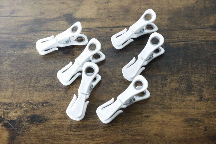 木目調のテーブルに置かれた白い多機能洗濯ピンチ6個