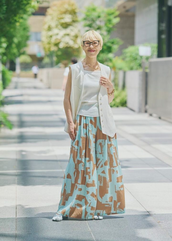 シャープな印象の、プリント柄パンツと白のベスト。