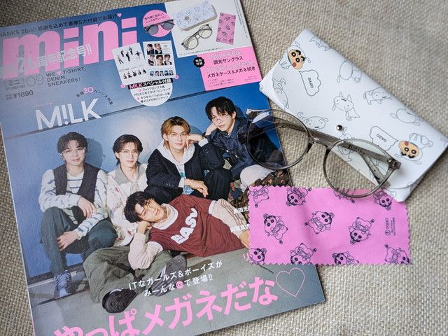 表紙とMILKFED.調光サングラス、メガネケース、メガネ拭きを並べた全体写真