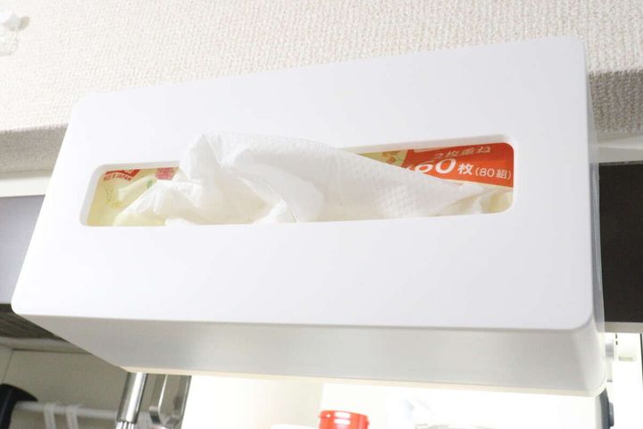 吊戸棚の下に横向きに取り付けられた「2WAYペーパータオルホルダー」からペーパータオルが出ている様子。