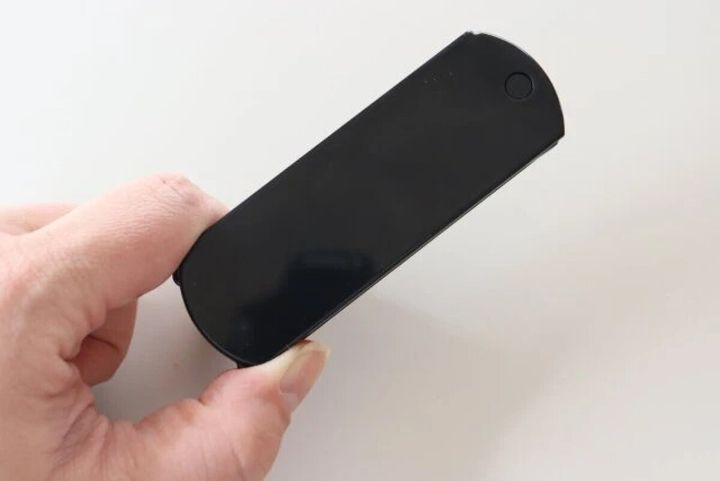 黒い折りたたみミラー付コームを指で持っている手元
