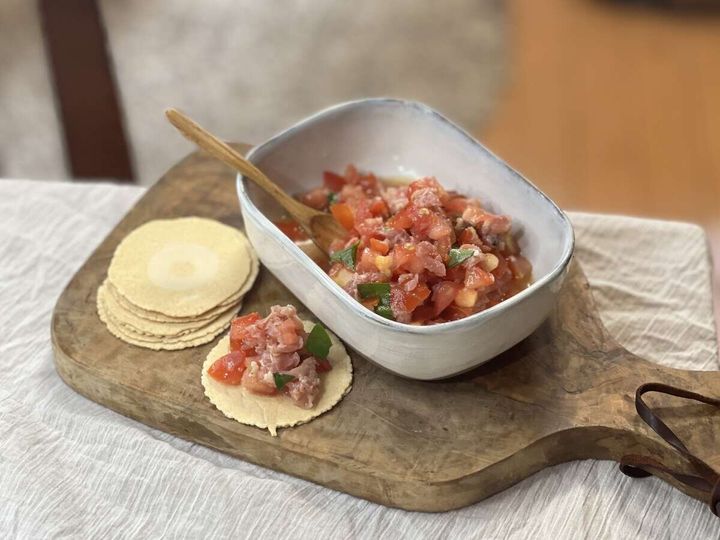 白い器に盛られたトマトと生ハムのタルタル。クラッカーを添え、一つにはタルタルが乗っている