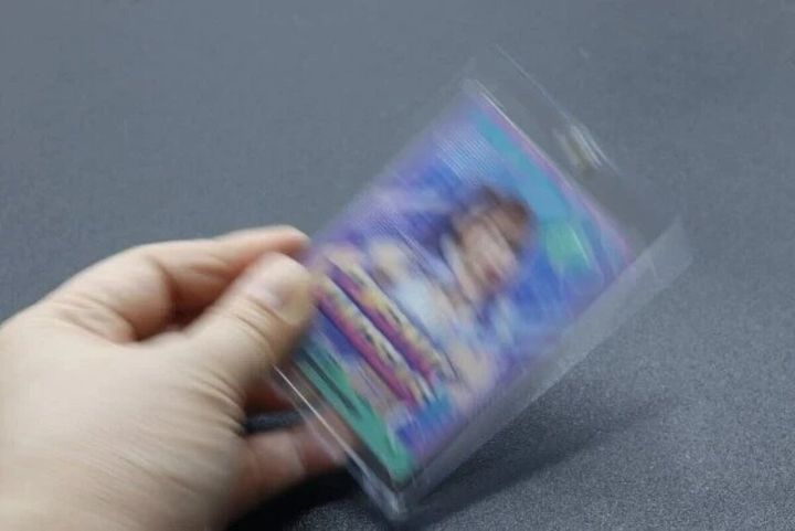 手が透明なカードローダーに入ったカードを振っている