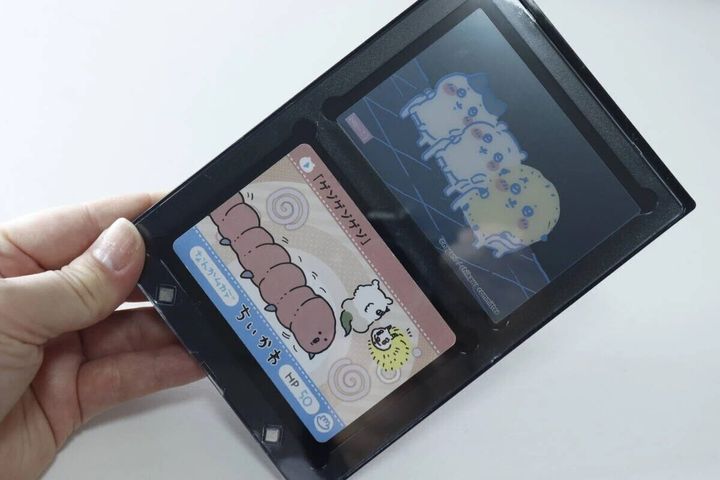手が黒い2連カードローダーにトレーディングカードをセットしている