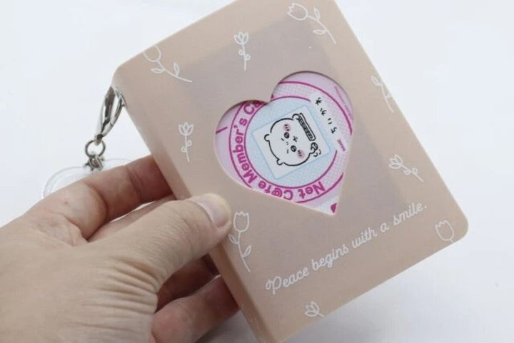 手がハート窓付きのピンクのカードファイルにカードをセットしている