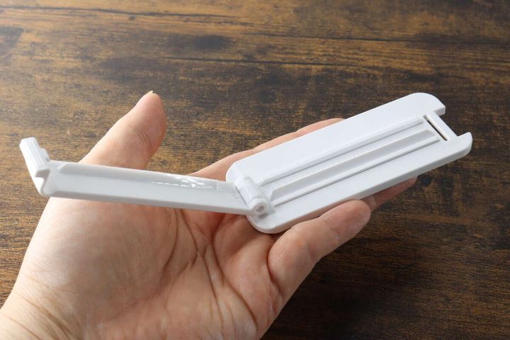 女性の手のひらに乗せたチューブしぼりを開いた状態