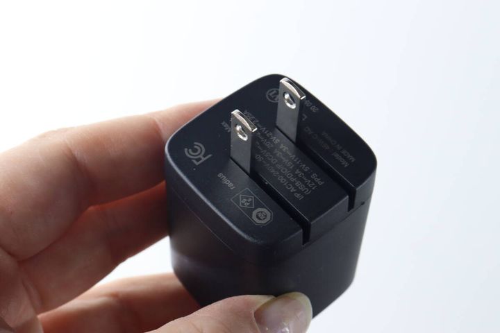 女性の指で持たれたGaN USB充電器の折りたたみプラグ