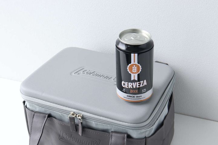 グレーの保冷バッグの蓋の上に黒い缶ビールが置かれている