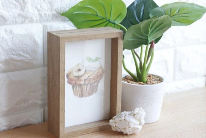 カップケーキのイラストが入ったフォトフレームと観葉植物
