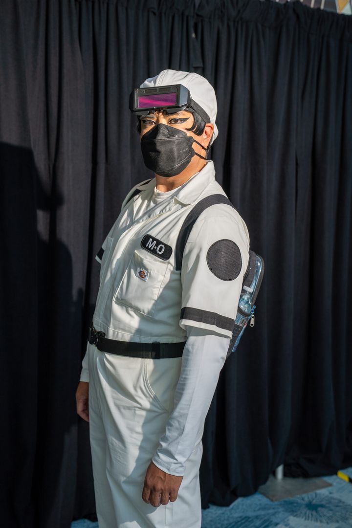 白いつなぎに「M・O」のネームパッチを付けたM-Oのコスプレイヤー