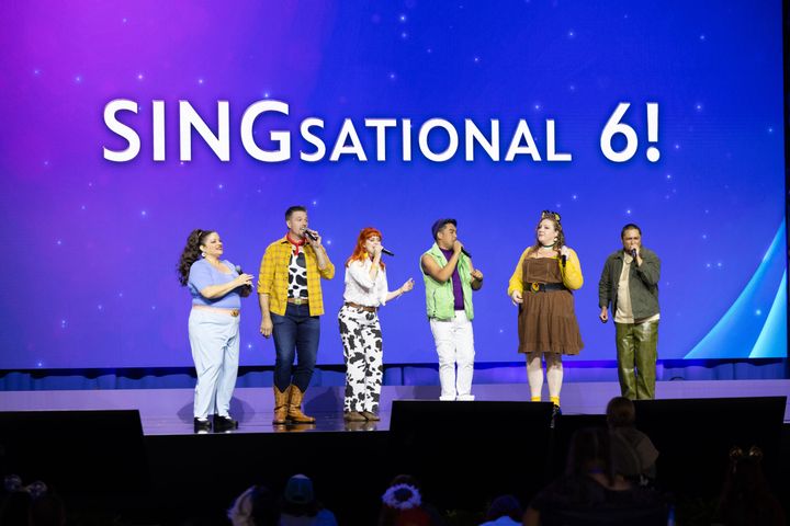 「SINGsational 6!」のタイトルを掲げたステージで横一列に並んで歌う出演者