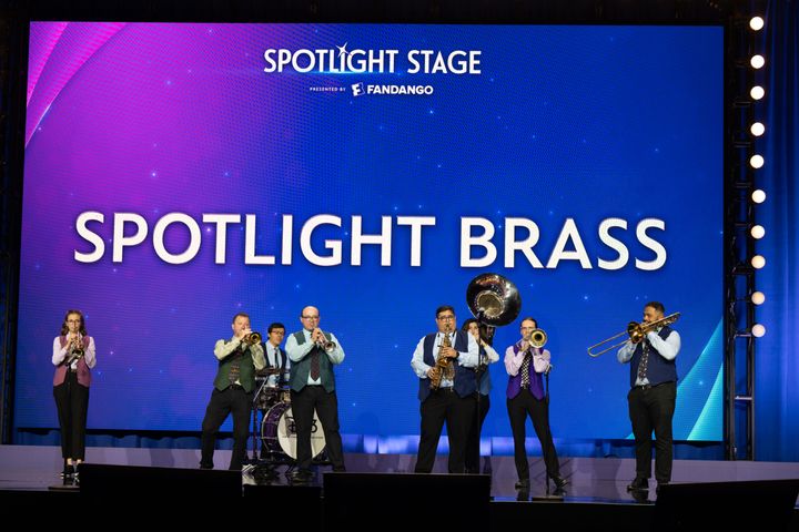 スクリーンに「SPOTLIGHT BRASS」を掲げたステージで横一列に並び演奏するブラスバンド