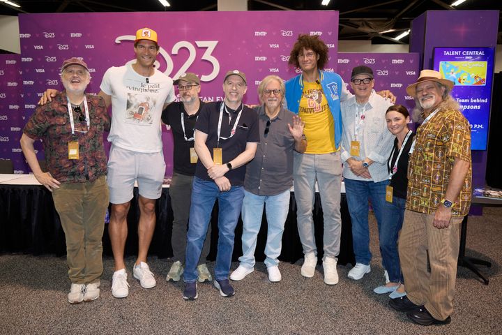 D23のバックドロップ前に並ぶ『ザ・シンプソンズ』のキャストと制作陣9人の集合写真