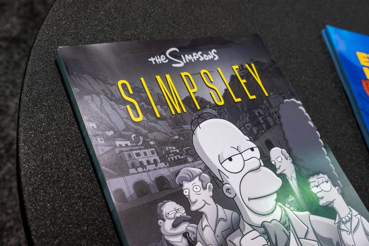 テーブルに置かれた「THE SIMPSONS」「SIMPSLEY」のポスター