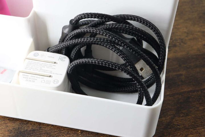 スタンドのポケットに黒い充電ケーブルと白い充電器