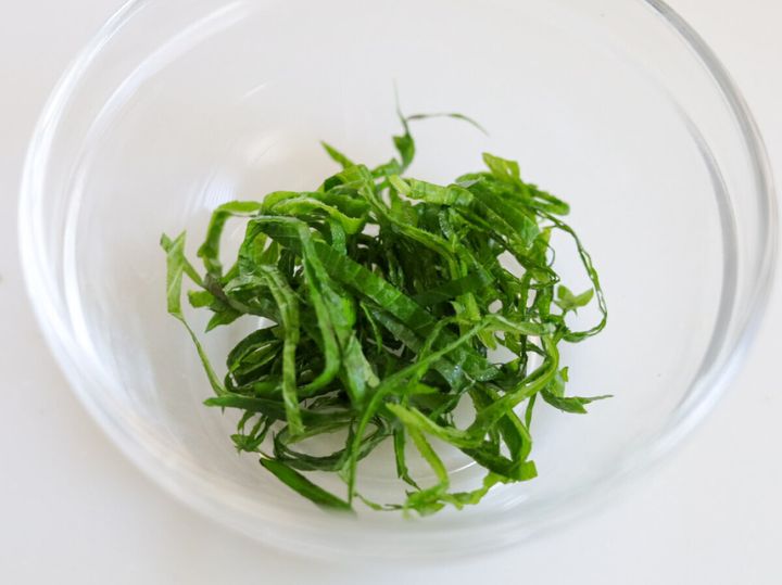 透明なガラスボウルに細切りにした青じそが盛られている様子