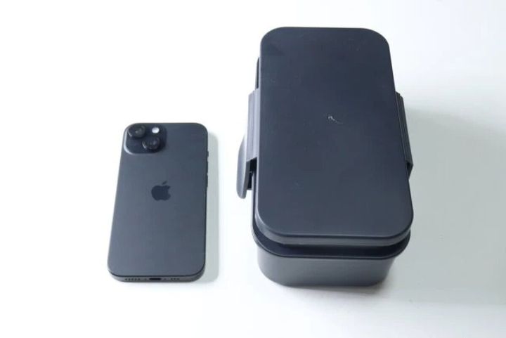 濃いグレーの三分割式弁当箱とスマートフォンを比較した様子