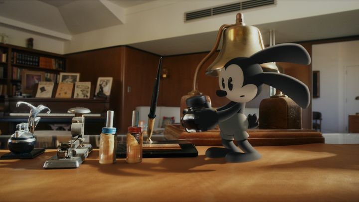 実写のウォルトのオフィスでインク瓶を手にするオズワルド・ザ・ラッキー・ラビット