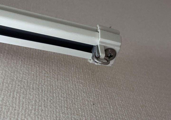 カーテンレールの端にあるキャップストップが取り付けられている様子