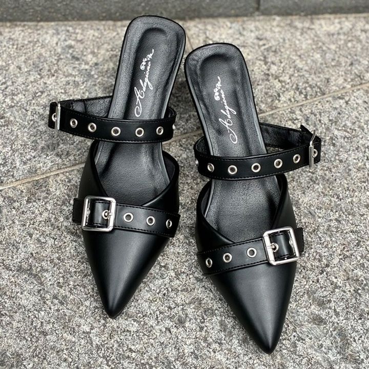 黒いポインテッドトゥのミュールパンプス。甲に2本のバックル付きベルトがある。