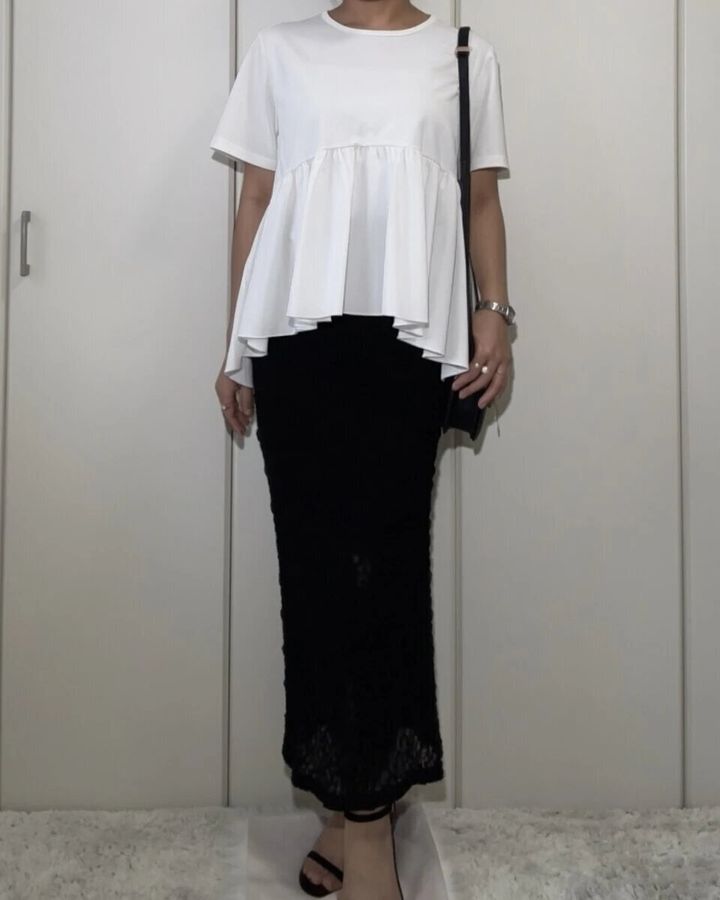 白いTシャツに黒いレースのナロースカートを合わせた女性の全身