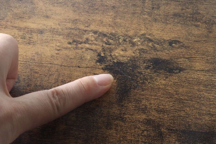 絵の具で補修され傷が目立たなくなった机の天板
