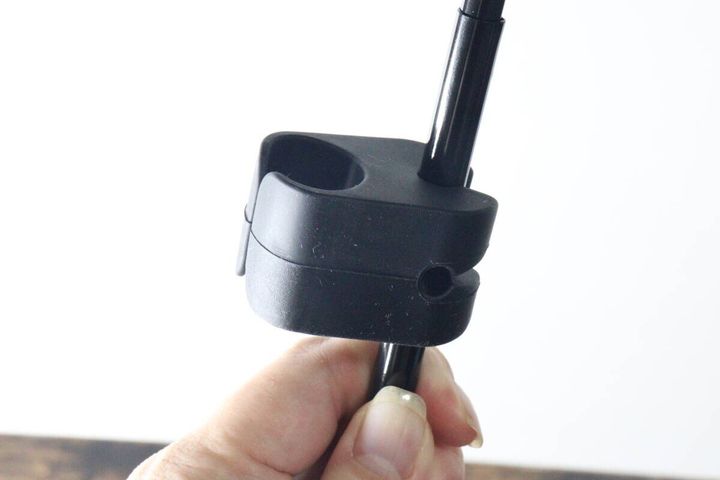 折りたたみ傘の中棒に黒いホルダーを取り付けている