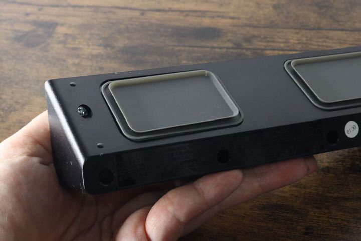 黒いテーブルタップの底面にある吸盤を指で示している