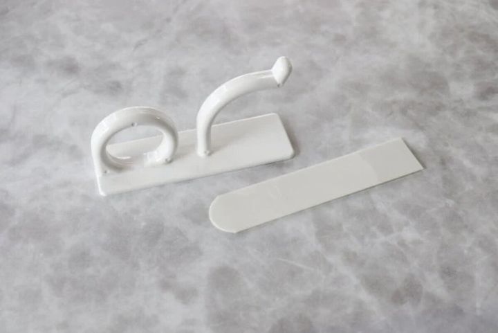 白いフックと粘着タブが大理石調の台に置かれている
