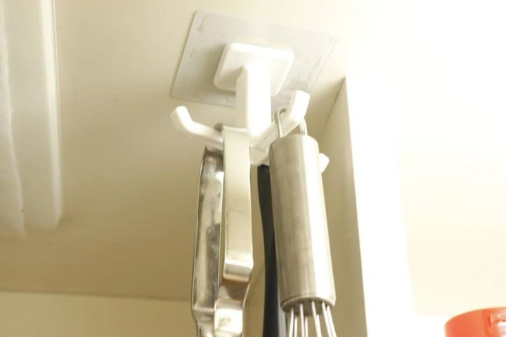 キッチン戸棚下の回転フックにキッチンツールが吊るされている