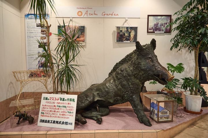 エスカレーターのそばに立つ「幸運の仔豚像・PORCELLINO」